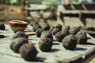 Close-up of colorful seed bombs nestled in natural brown paper packaging on a wooden table.