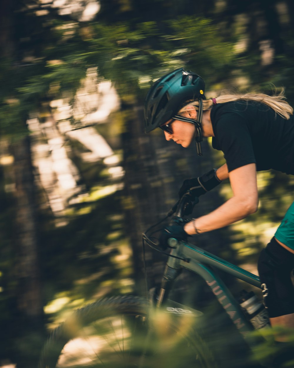 Woman rides a women-specific Juliana mountain bike through the forest