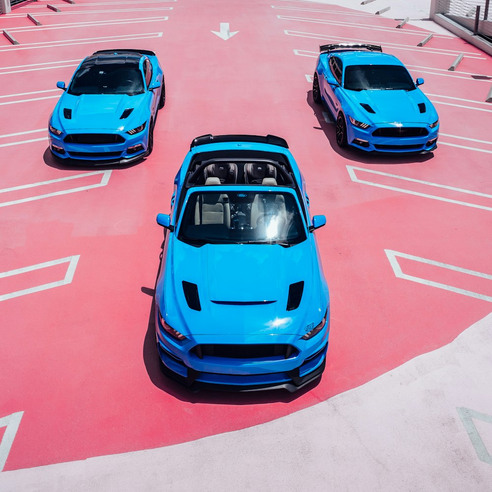 blue car on red and white road