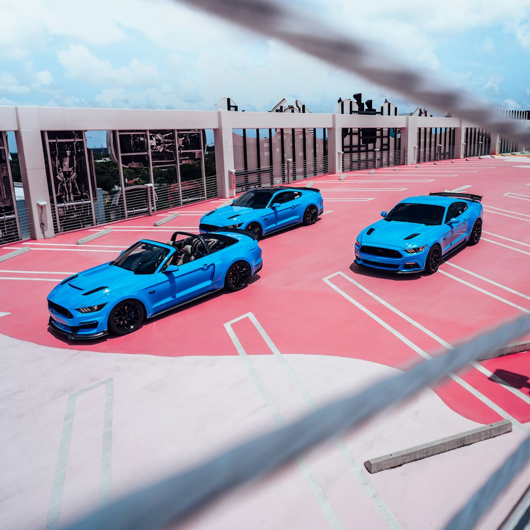red and blue cars on parking lot during daytime