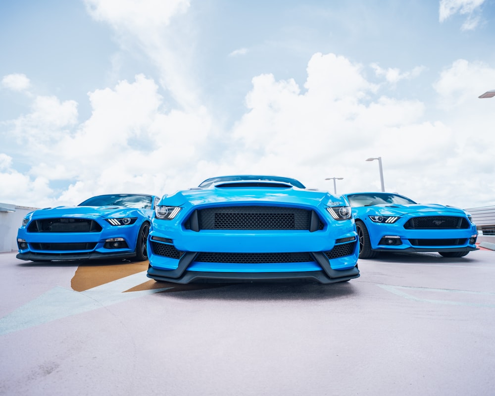 blue chevrolet camaro on parking lot under white clouds during daytime