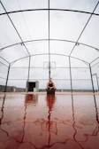 Athlete performing intense ball control exercises on a worn-out outdoor court.