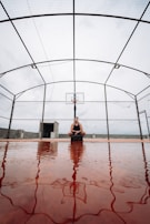 Athlete wearing a waist support while playing an intense game of basketball outdoors.