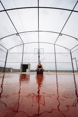 Athlete performing intense ball control exercises on a worn-out outdoor court.