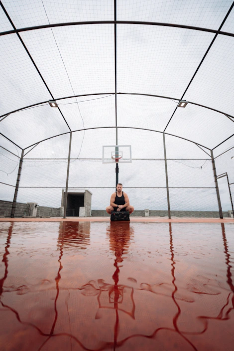 Athlete wearing sturdy knee pads while preparing for a game on an outdoor court.
