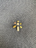 A collection of various shaped pills and tablets is arranged on a woven, textured surface with a circular pattern.
