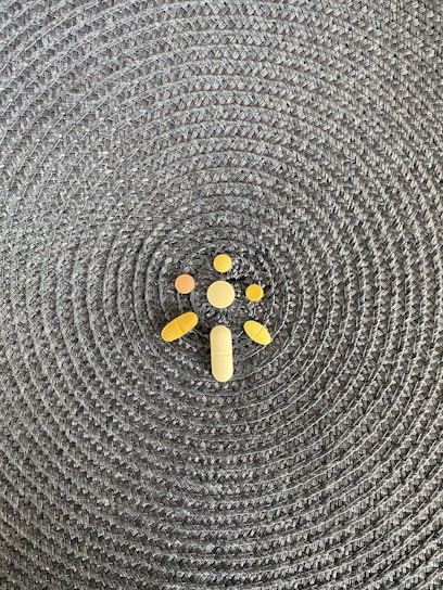 Close-up of various pharmaceutical capsules and tablets arranged neatly on a reflective surface.