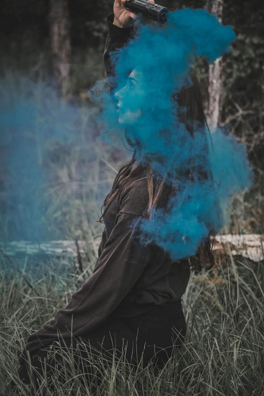 person in black jacket with blue smoke
