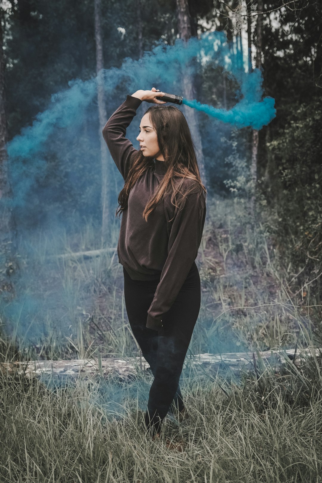 woman in brown hoodie standing on green grass field