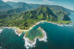 An aerial view of a lush green coastline with mountains and a coral reef