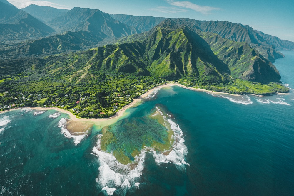 aerial view of green and brown mountains and lake