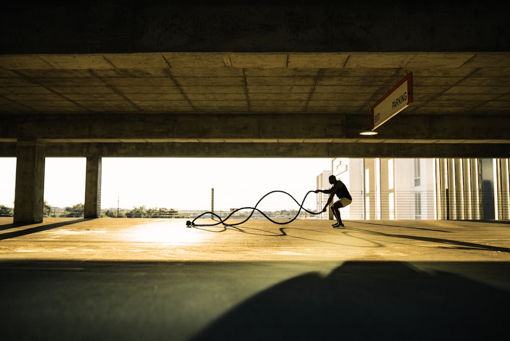 man in black shirt and pants riding bicycle on gray concrete road during daytime