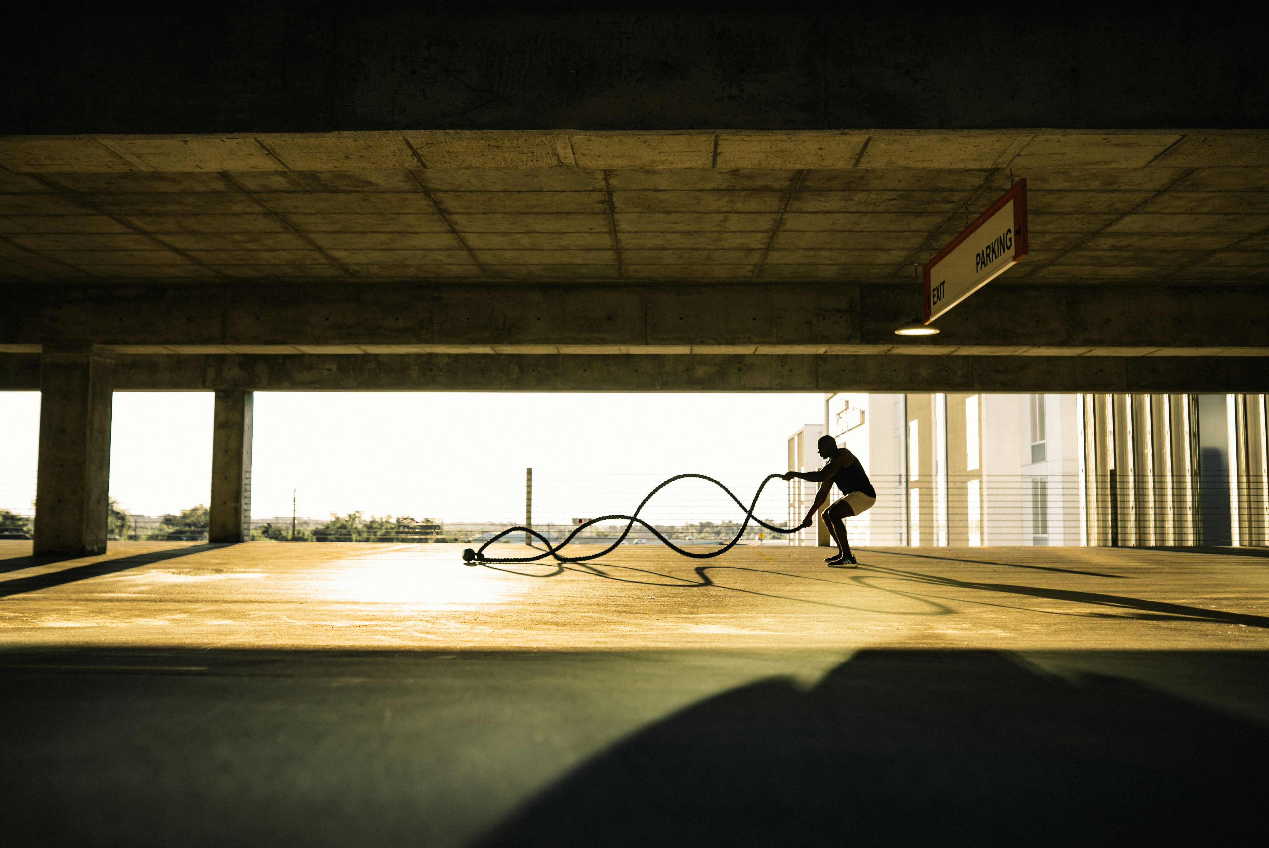 man in black shirt and pants riding bicycle on gray concrete road during daytime