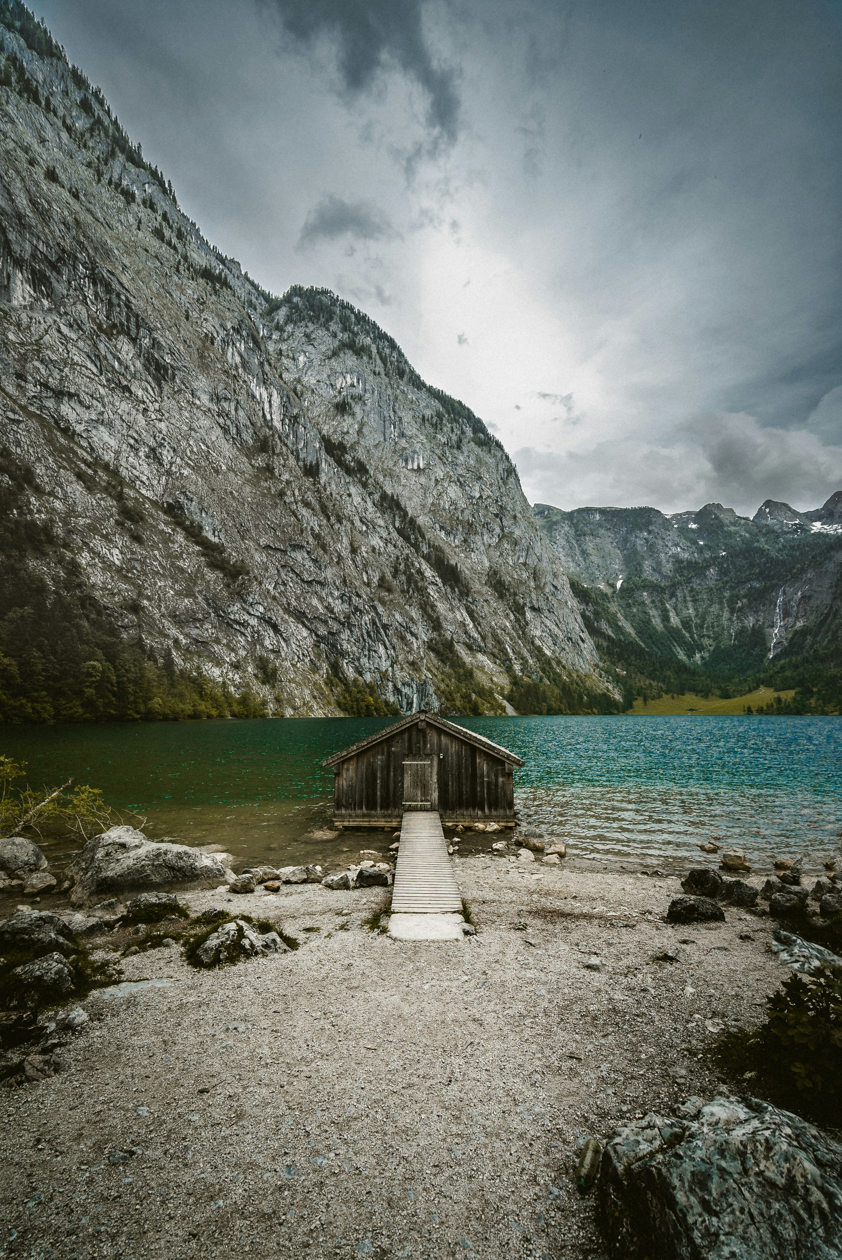 Brown wooden house on seashore near mountain during daytime photo ...