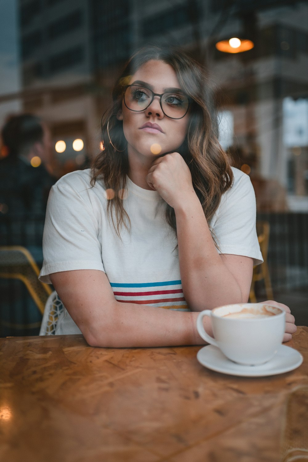 woman in white crew neck t-shirt wearing eyeglasses sitting at the table