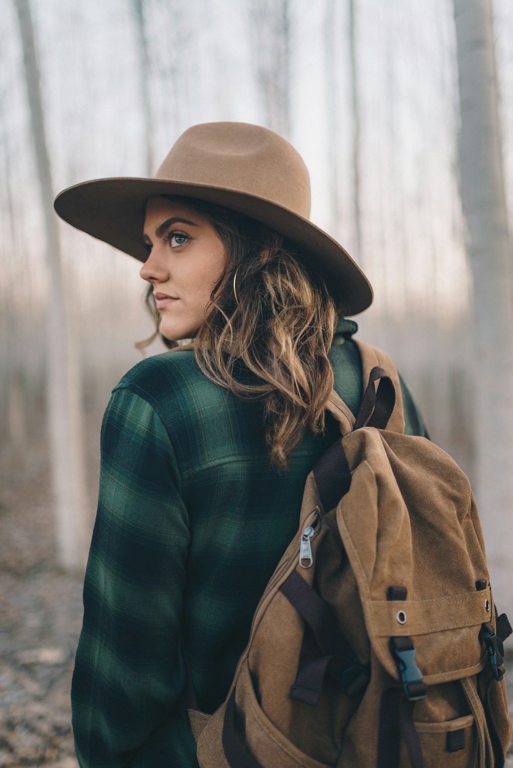 woman in green and black sweater wearing brown hat