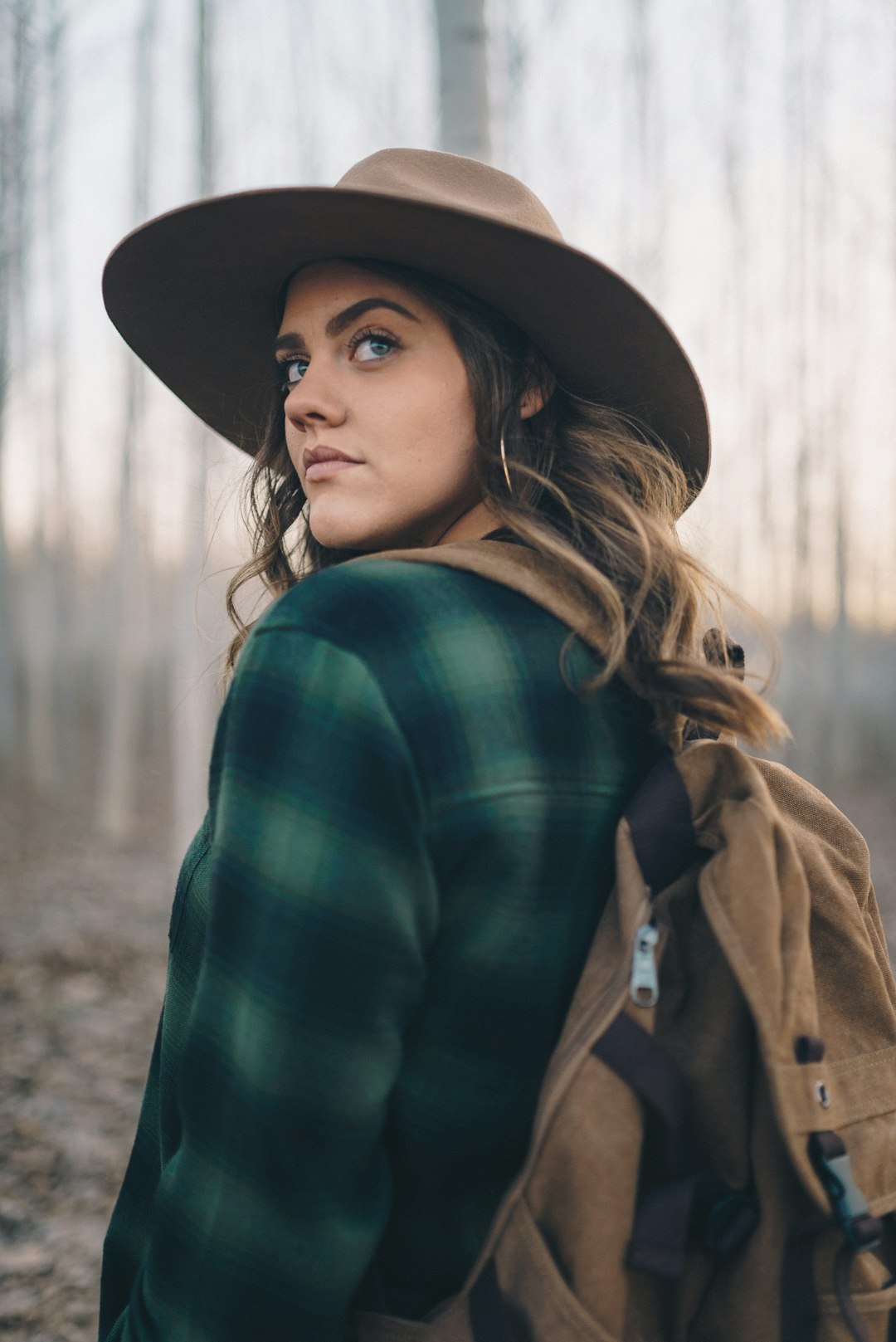 woman in green and black plaid long sleeve shirt wearing black hat