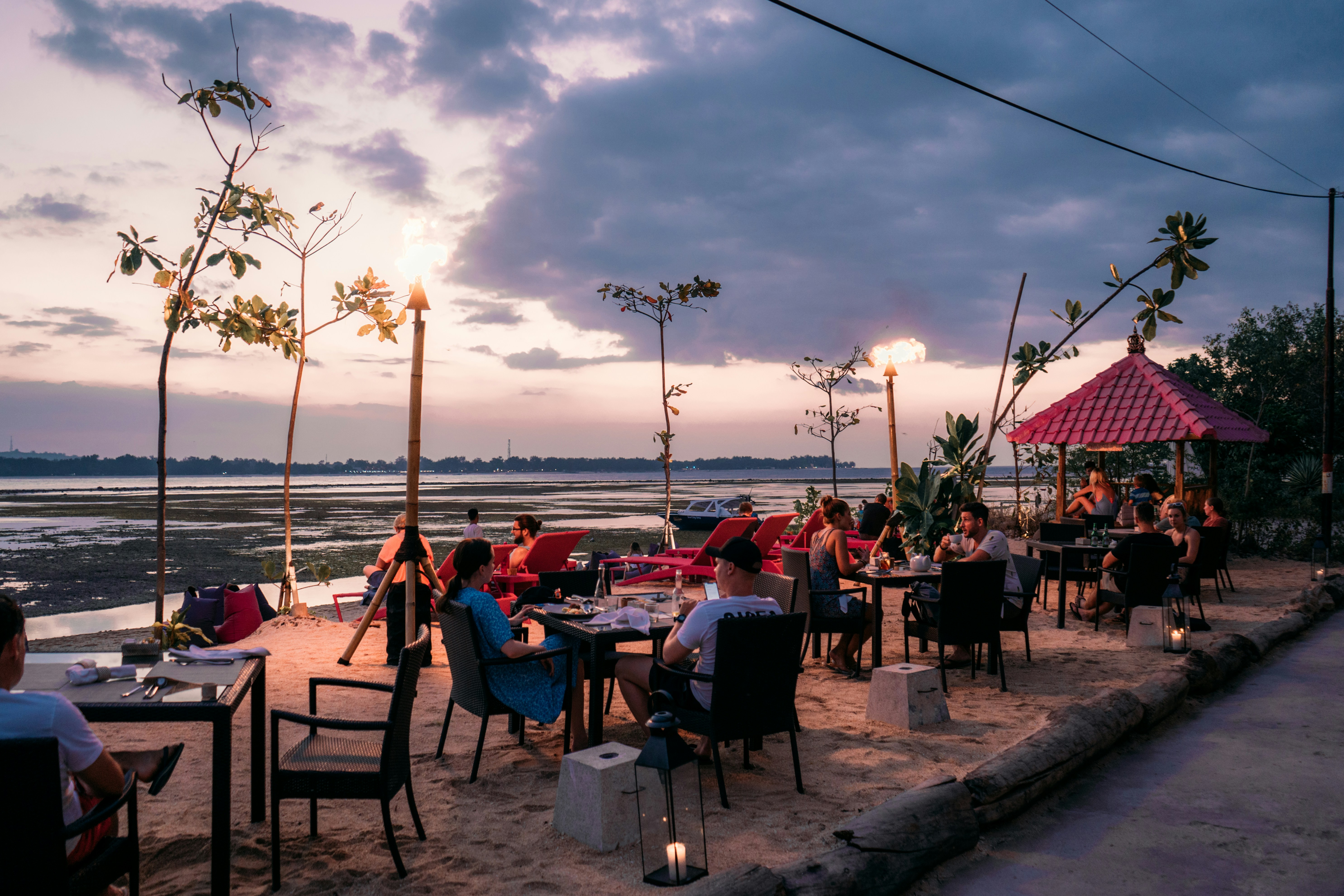 people sitting on chairs near beach during sunset