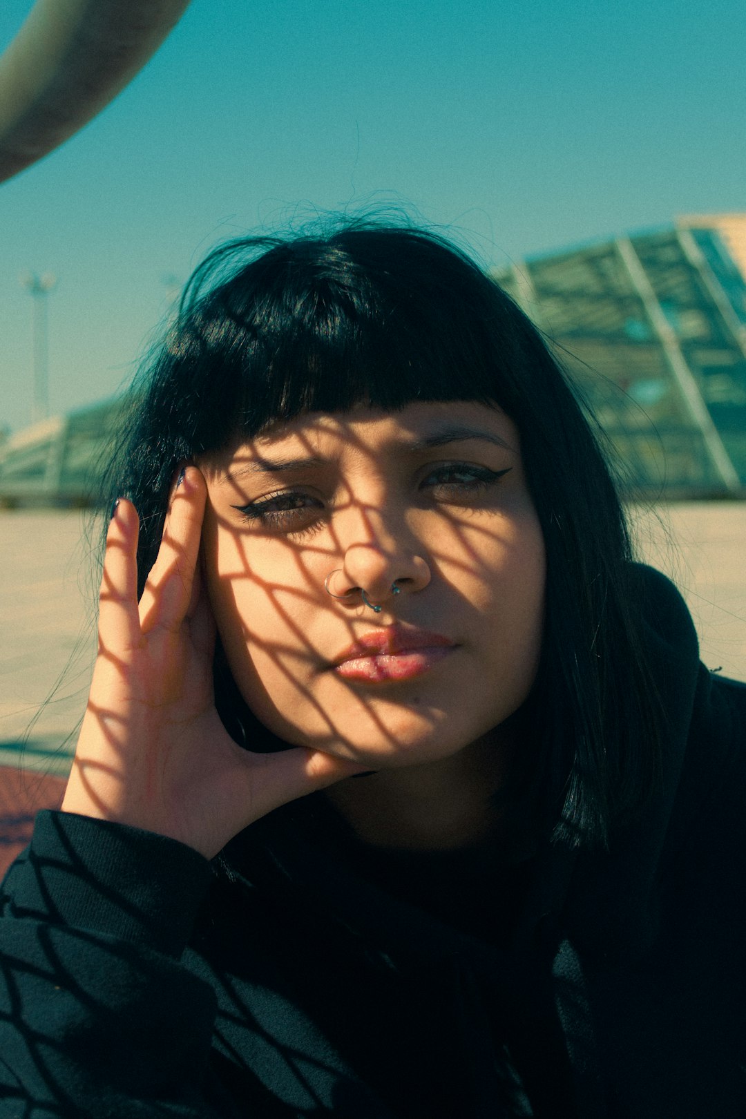 woman in black shirt covering her face with her hand