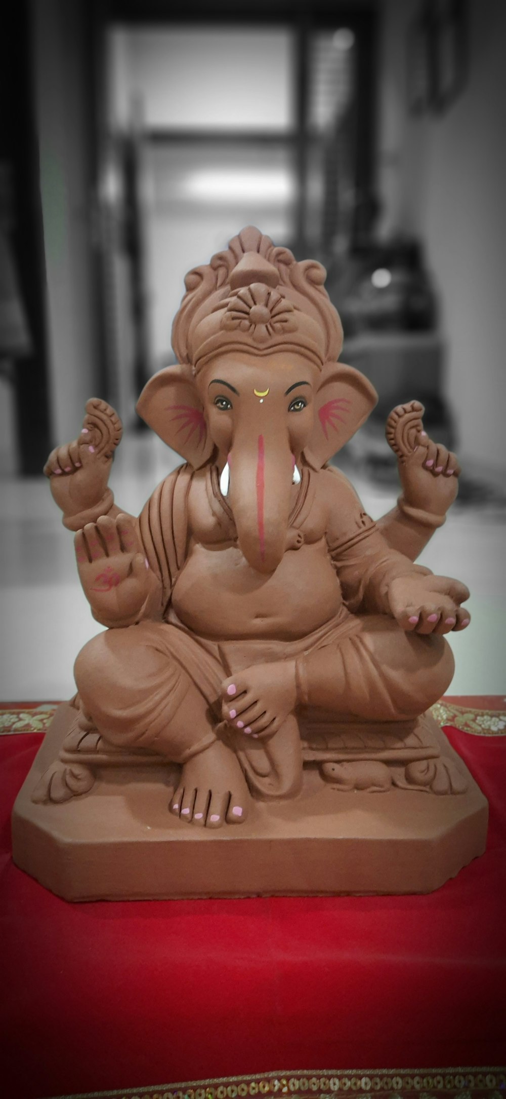 gold buddha figurine on red and white table cloth