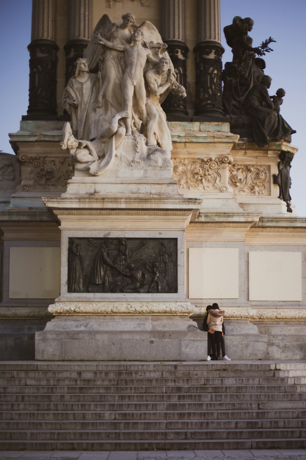 woman in black jacket standing in front of statue