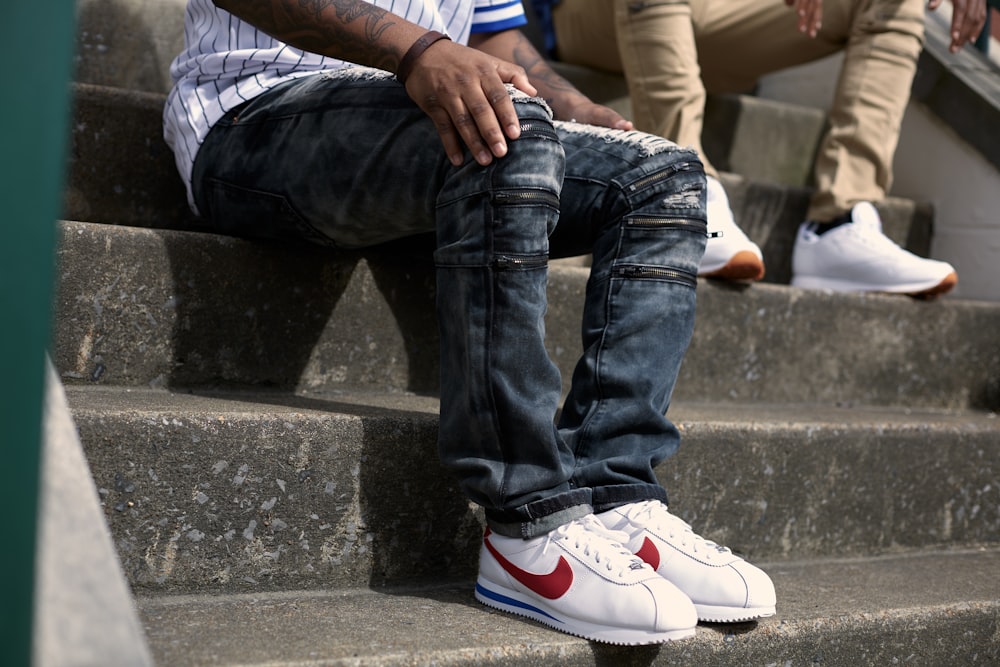 Foto persona con jeans azules y zapatillas nike blancas – Imagen Sitting  gratis en Unsplash