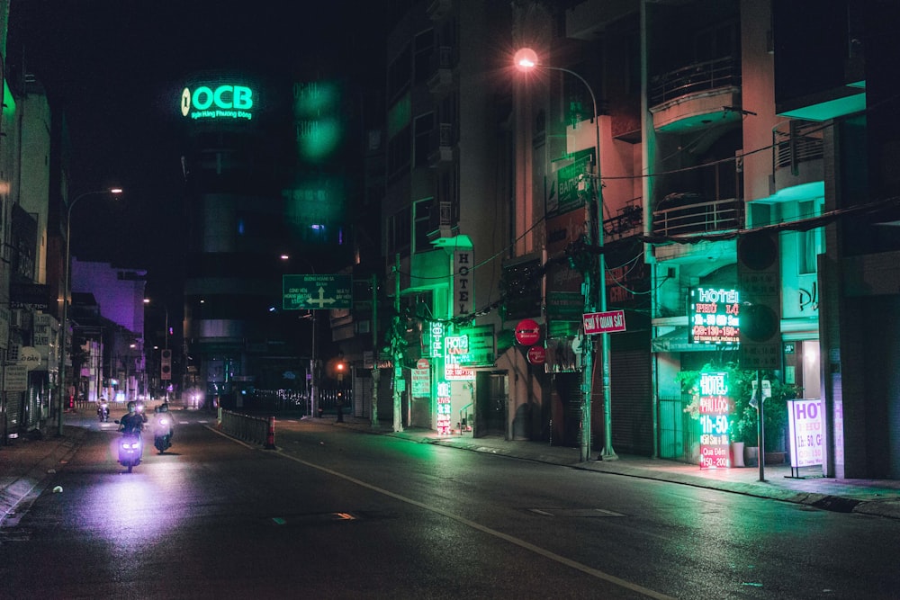street with green lights night time photo – Building Image Unsplash