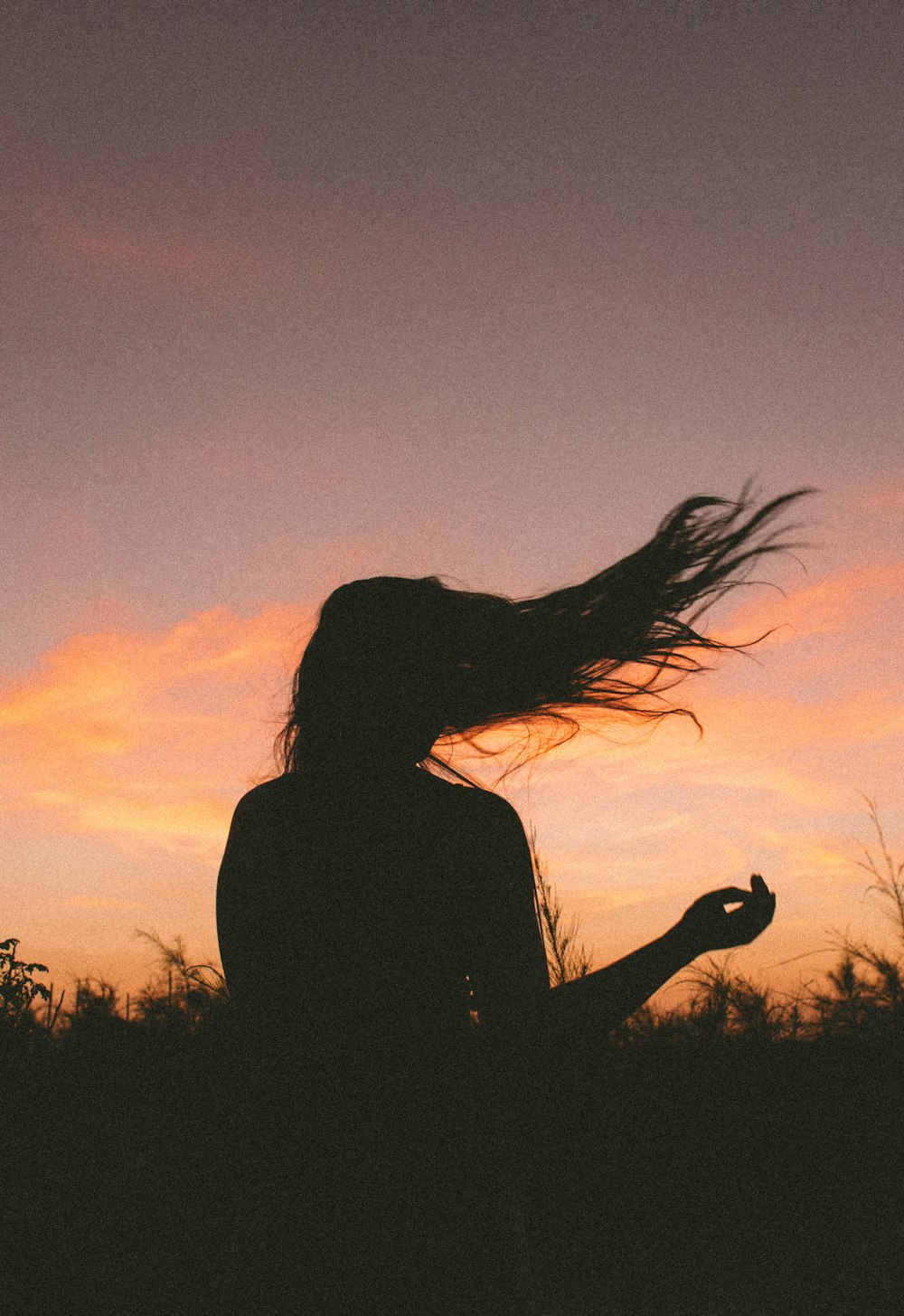 Silueta de mujer durante la puesta del sol