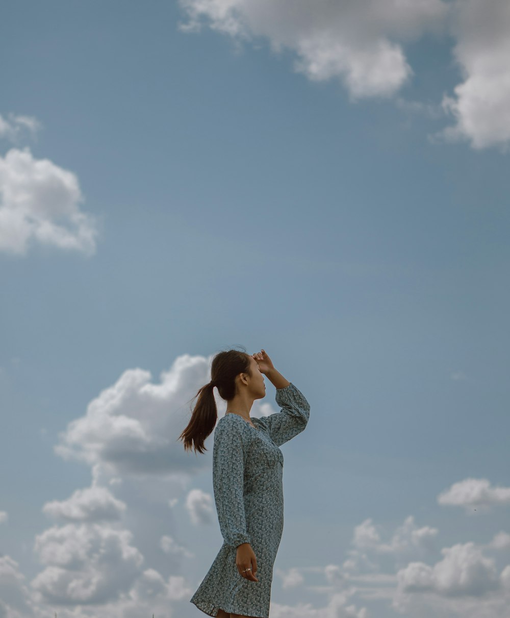 woman in white and black long sleeve shirt standing under blue sky during daytime