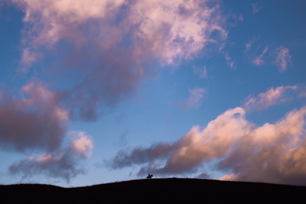 silhouette of mountain under cloudy sky during daytime