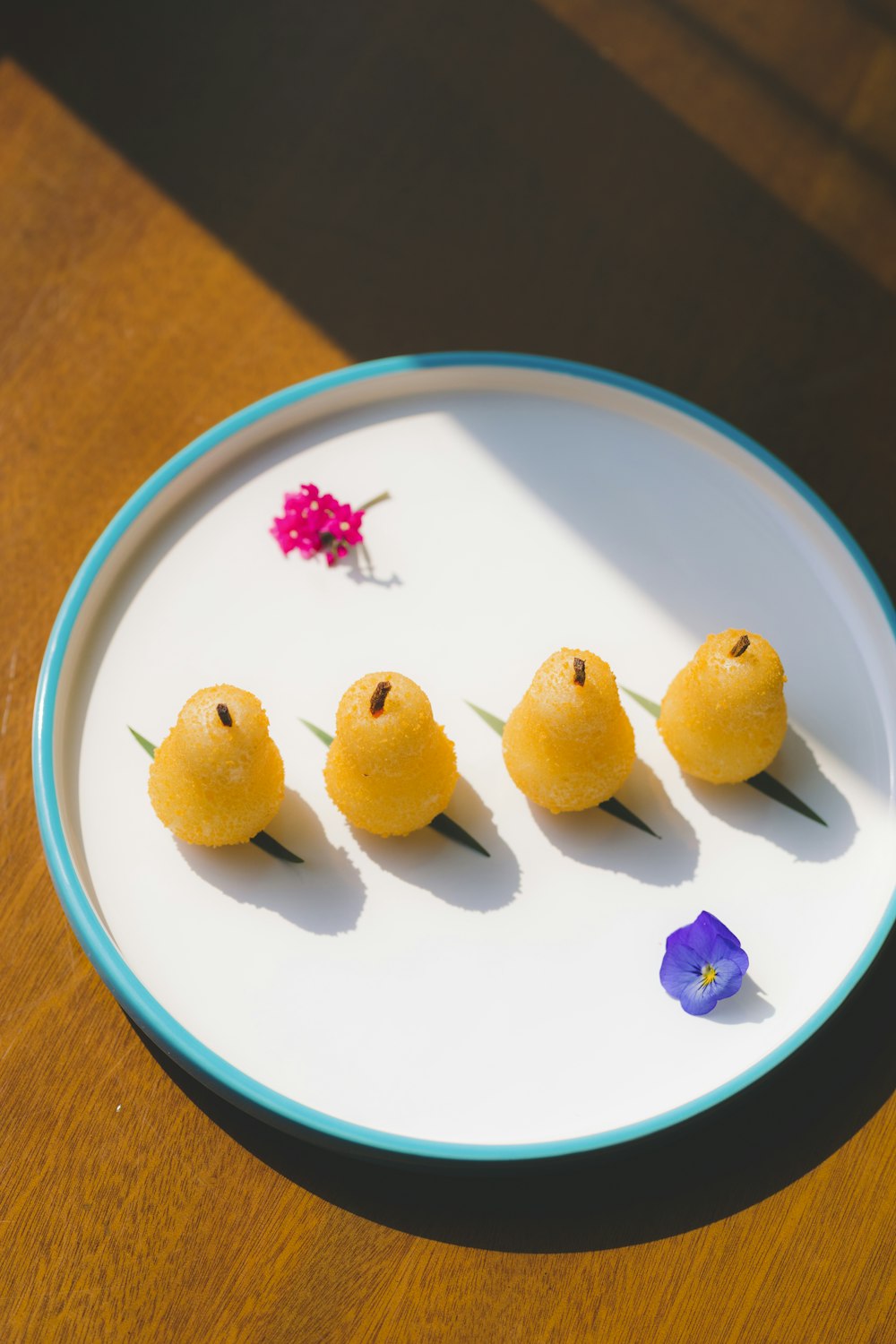 three yellow fruits on white and blue round plate