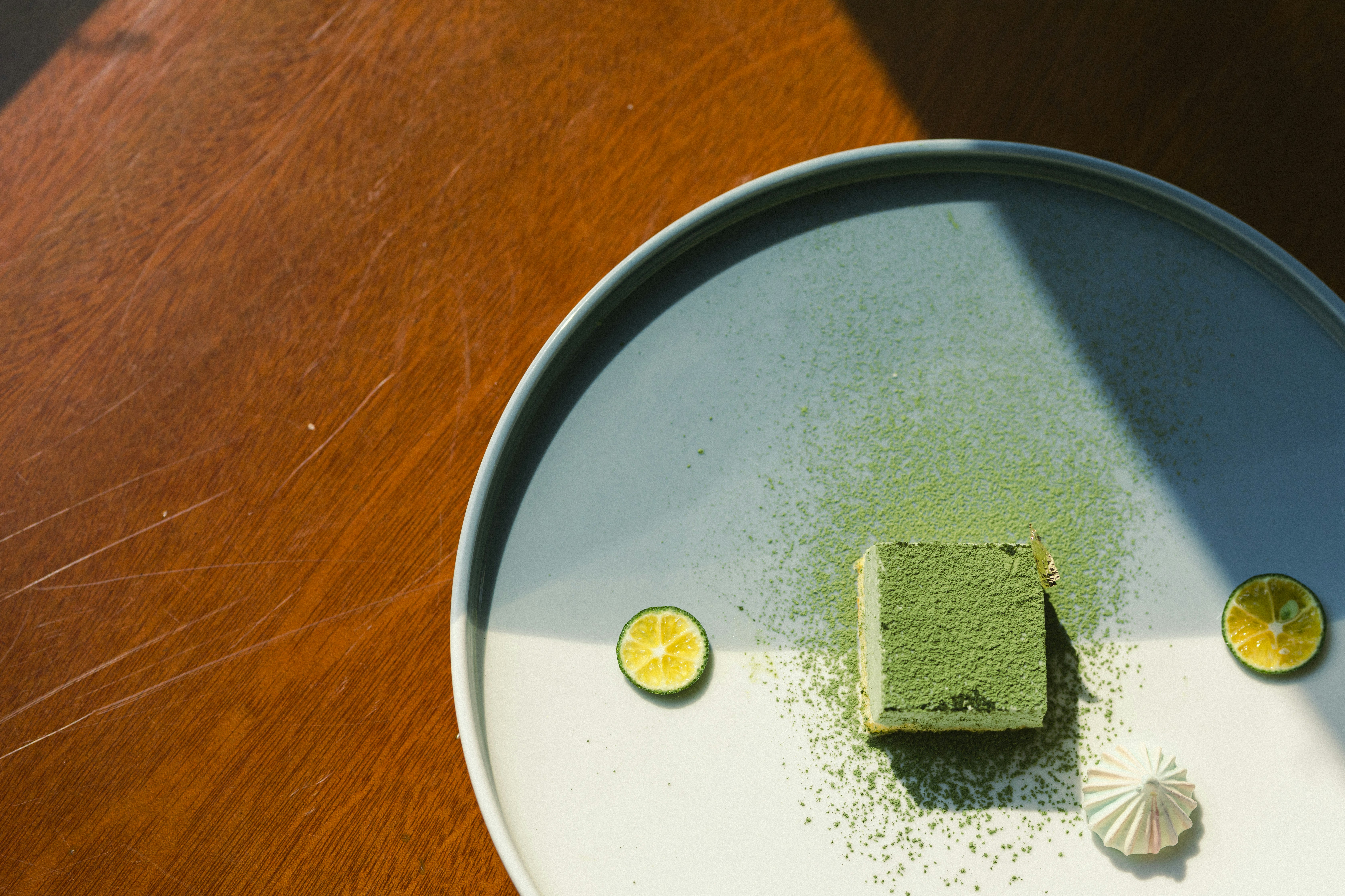 Square of matcha dessert on a white plate