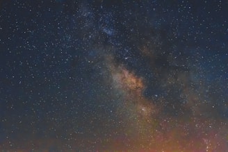 A breathtaking view of a star-filled night sky with the Milky Way galaxy prominently visible. The image captures the dense cluster of stars and cosmic dust in vibrant colors.