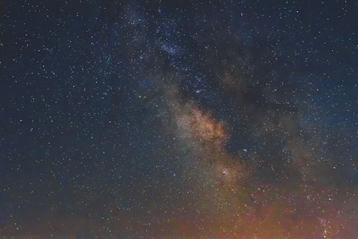 A breathtaking view of a star-filled night sky with the Milky Way galaxy prominently visible. The image captures the dense cluster of stars and cosmic dust in vibrant colors.