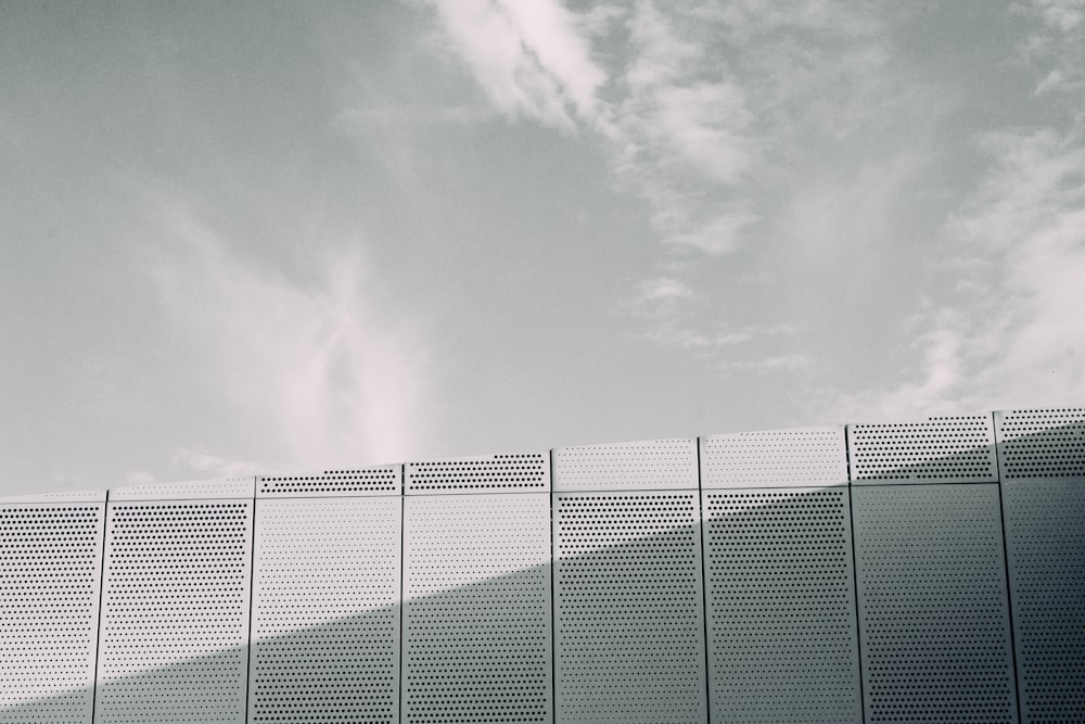 black metal fence under gray clouds