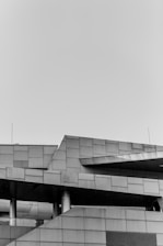grayscale photo of building under cloudy sky