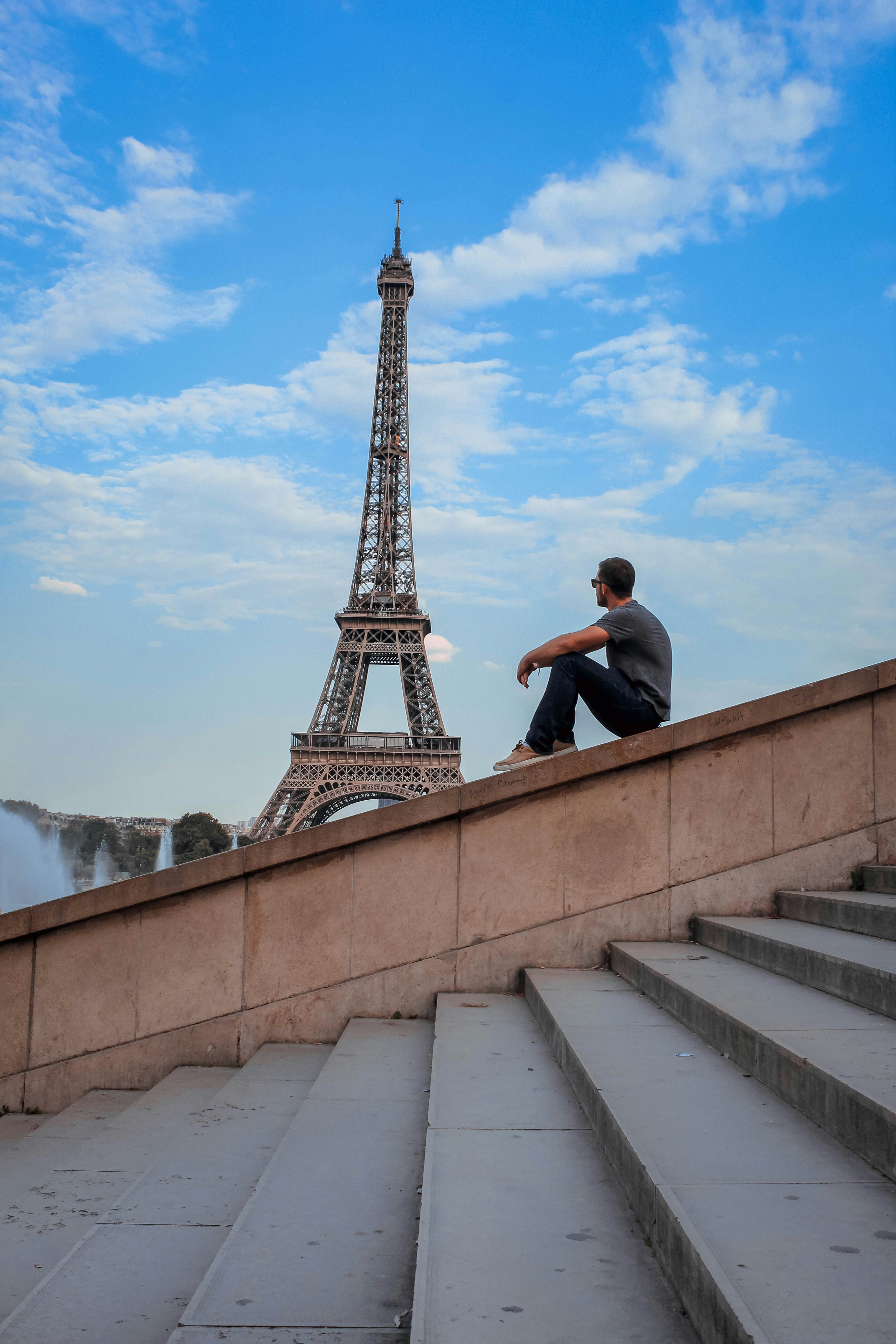 man in black jacket sitting on concrete stairs