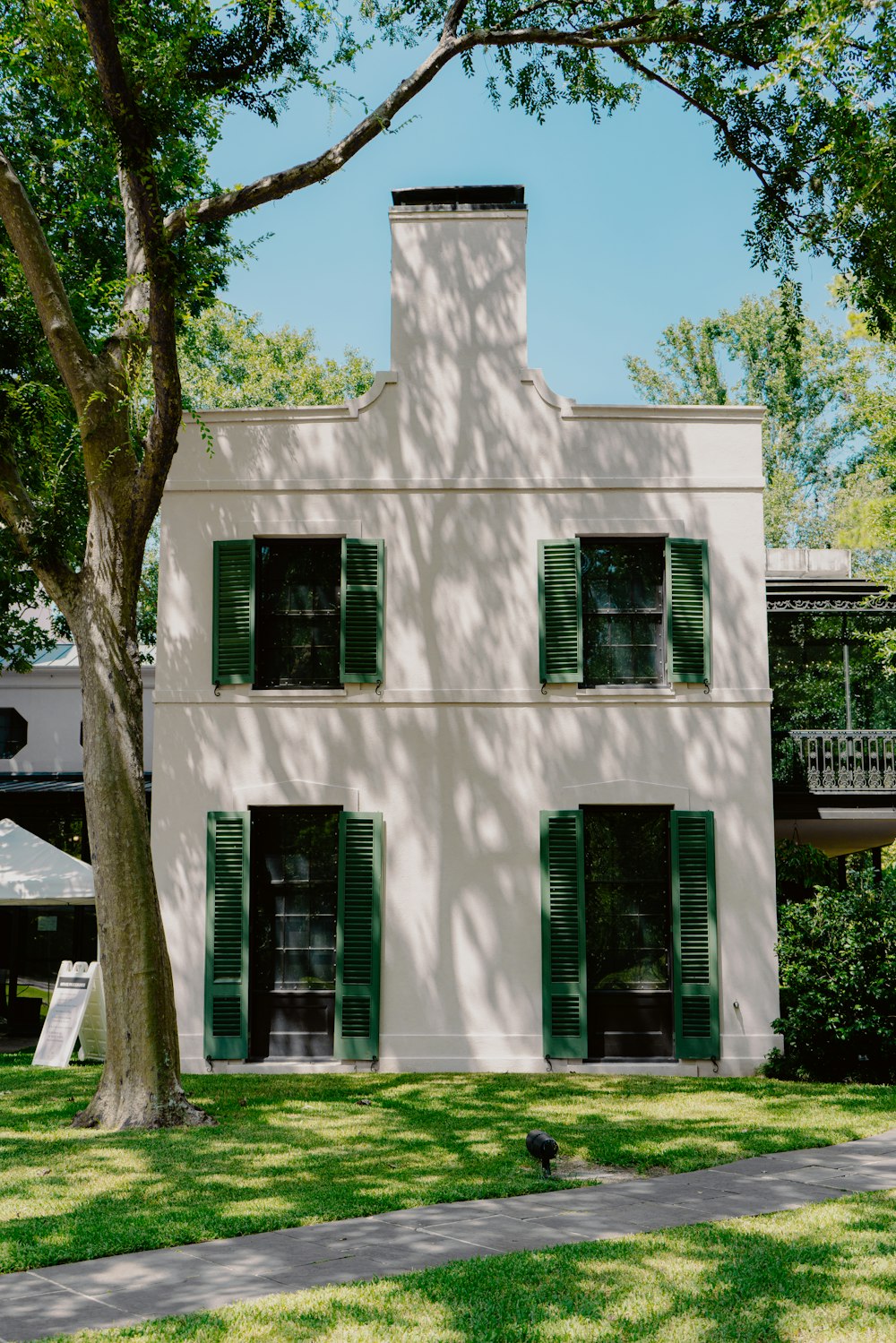 white concrete building near green tree during daytime