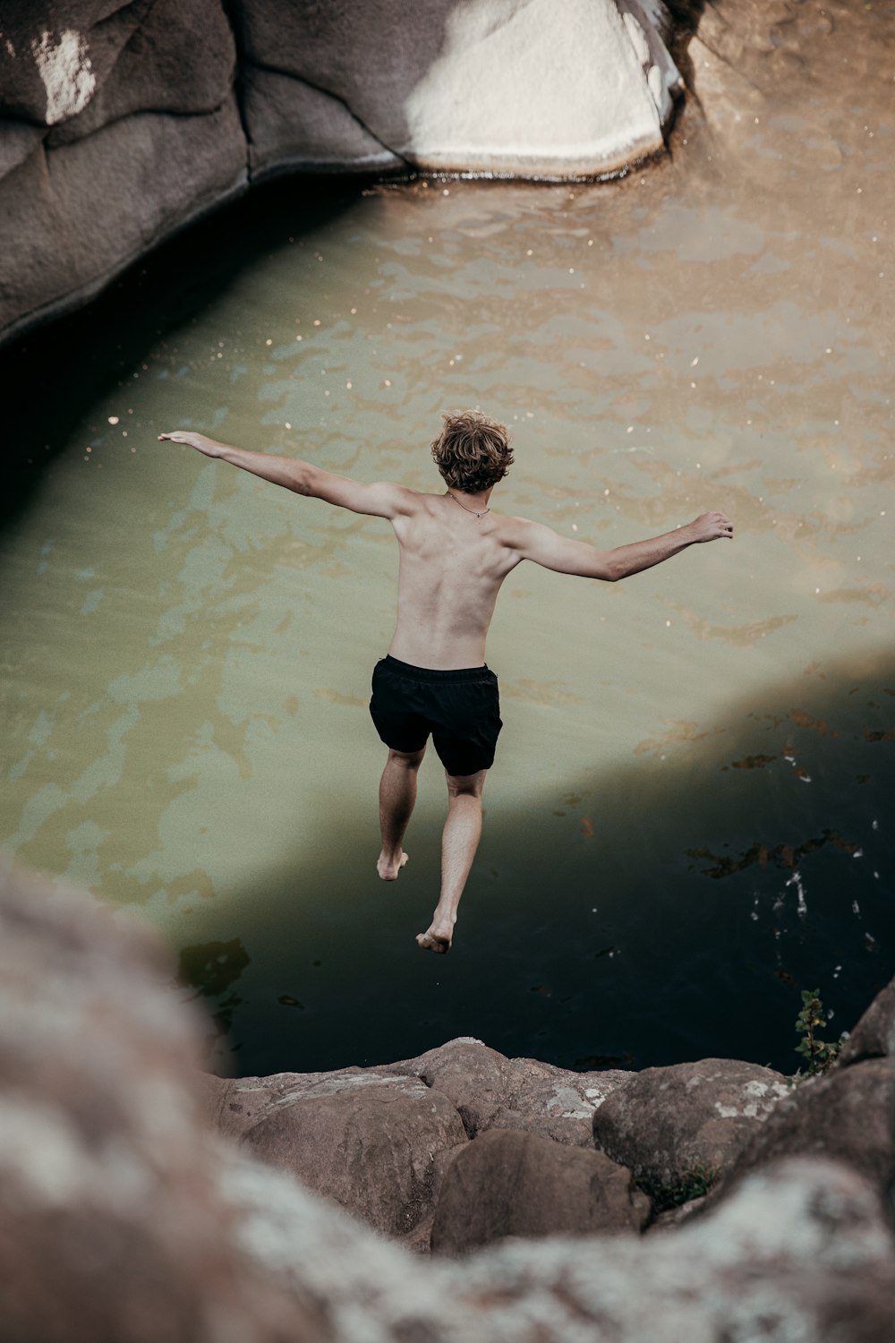 man in black shorts standing on water during daytime