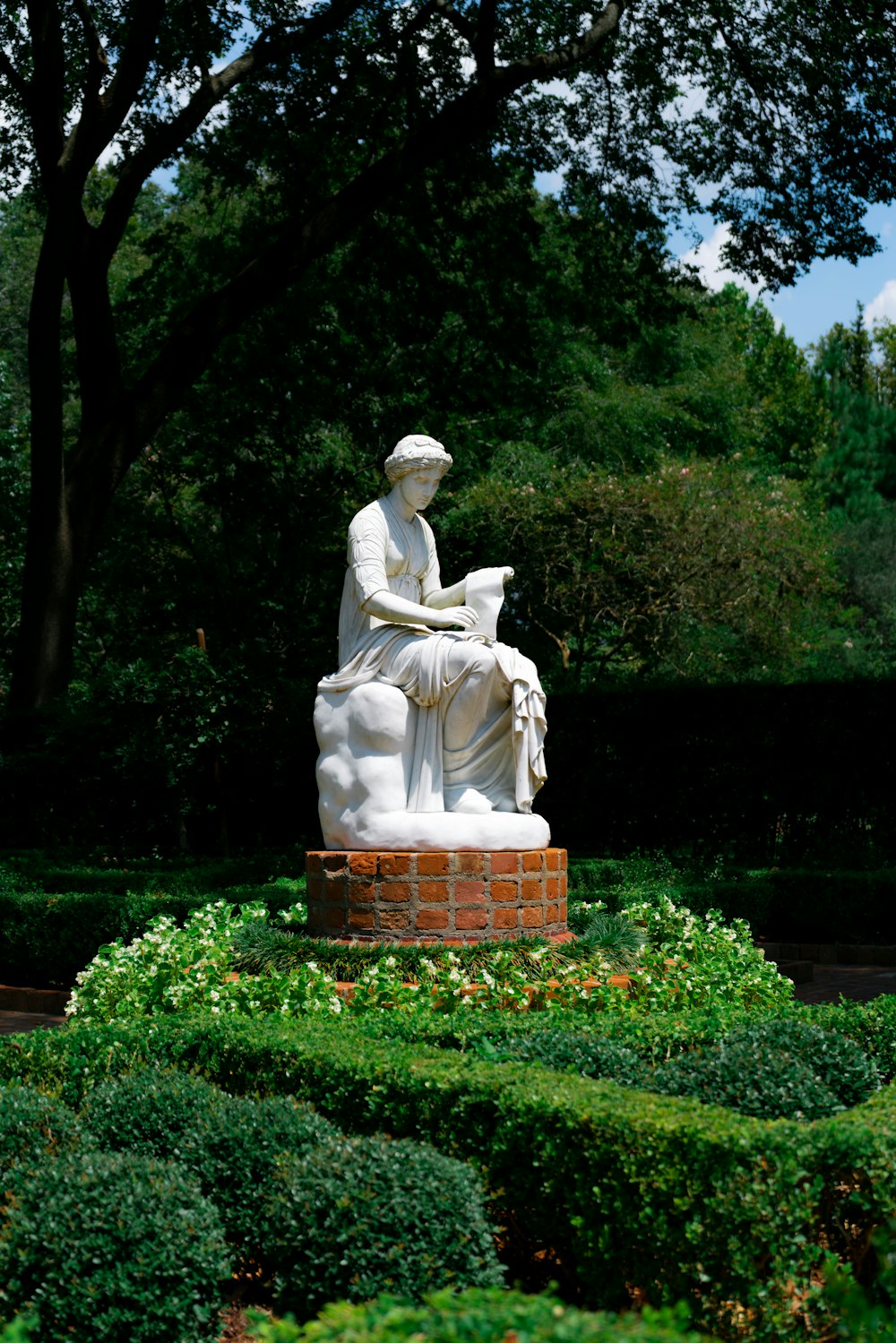 white statue of man holding book