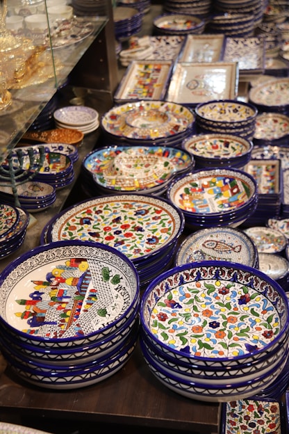 A beautifully arranged display of handmade food plates and ceramic tableware showcasing earthy colors and textures.