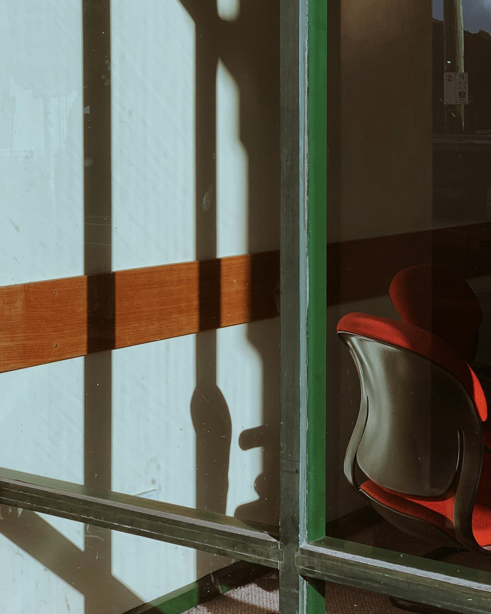 red and black chair beside glass window