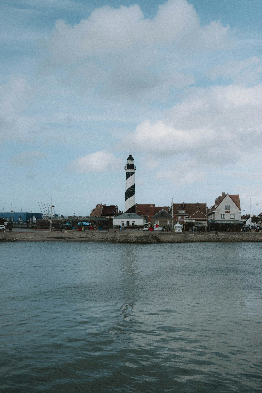 white and black striped lighthouse near body of water during daytime