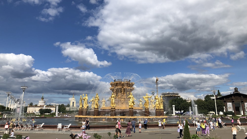 pessoas andando no parque sob o céu nublado ensolarado azul e branco durante o dia