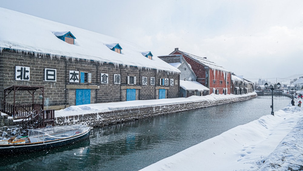 Bateau blanc sur l’eau près d’un bâtiment en béton brun pendant la journée