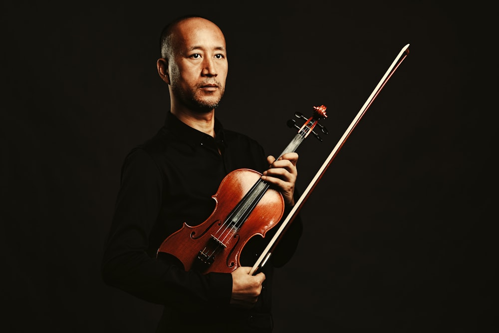 man in black v neck shirt playing violin