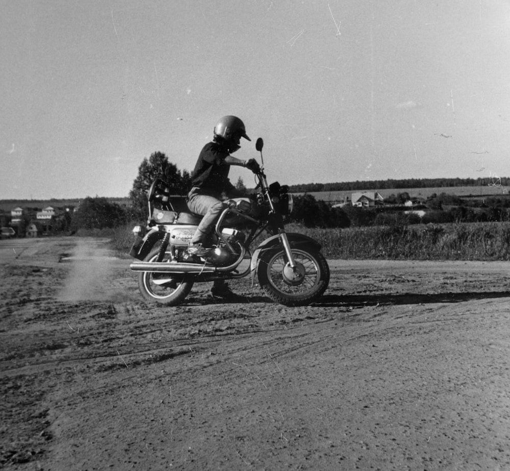 grayscale photo of man riding motorcycle