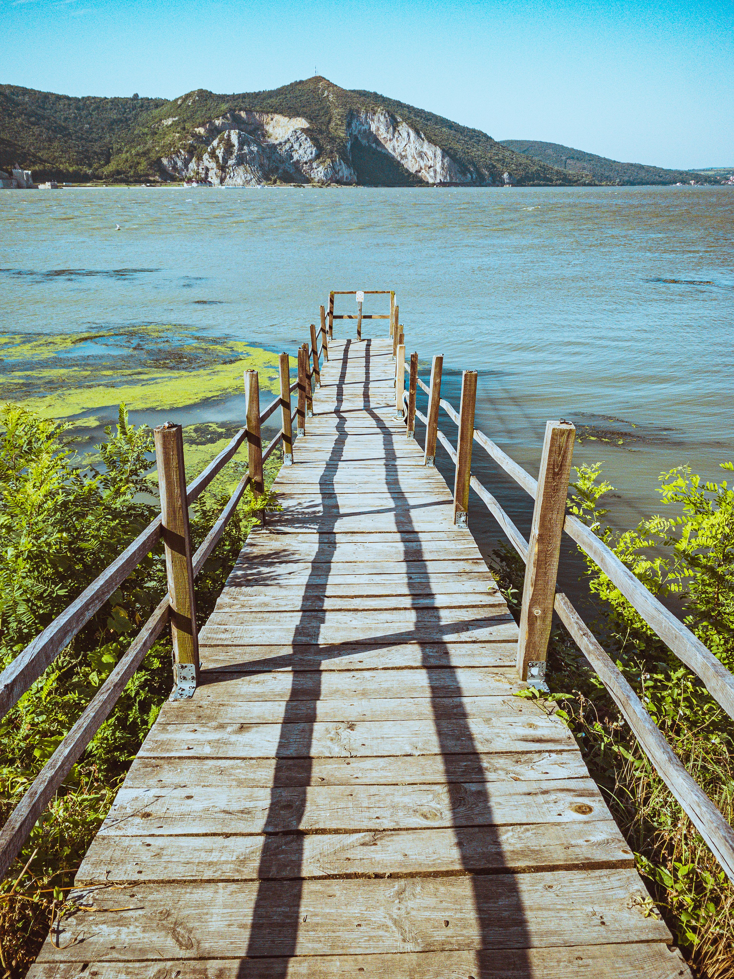 brown wooden bridge over blue sea during daytime