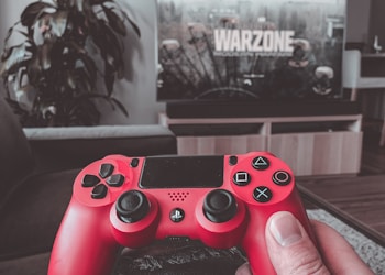person holding red sony ps 4 controller