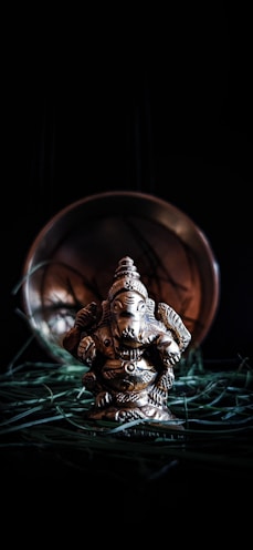 gold human figurine on green grass